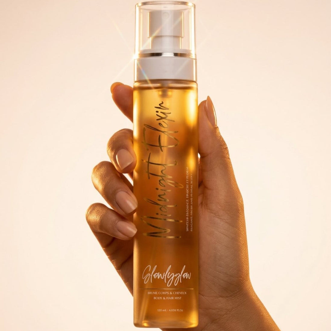 Prume parfumée Midnight Elixir GlowlyGlow pour le corps et les cheveux, tenue en main sur fond beige.